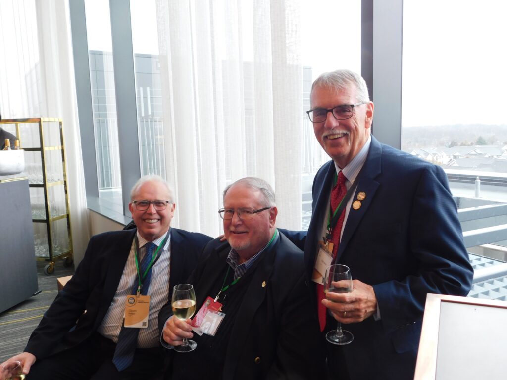 three men in suits and ties holding wine glasses