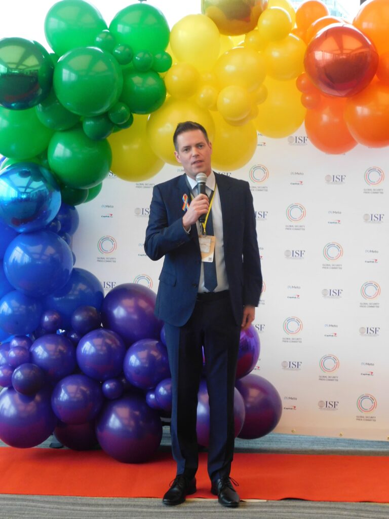 a man standing in front of balloons holding a microphone