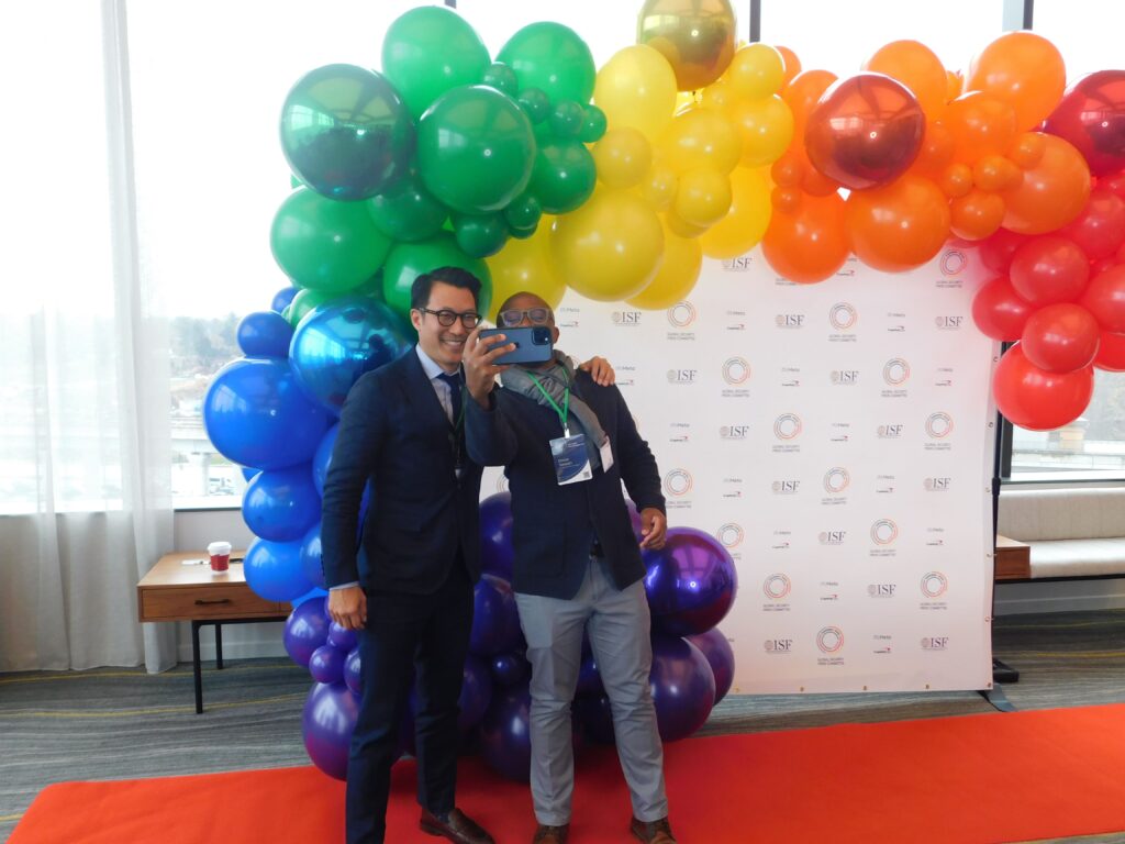 two men taking a photo in front of balloons