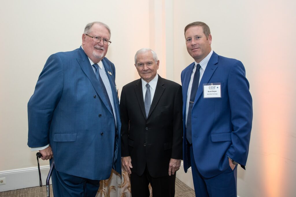 three men standing next to each other in suits