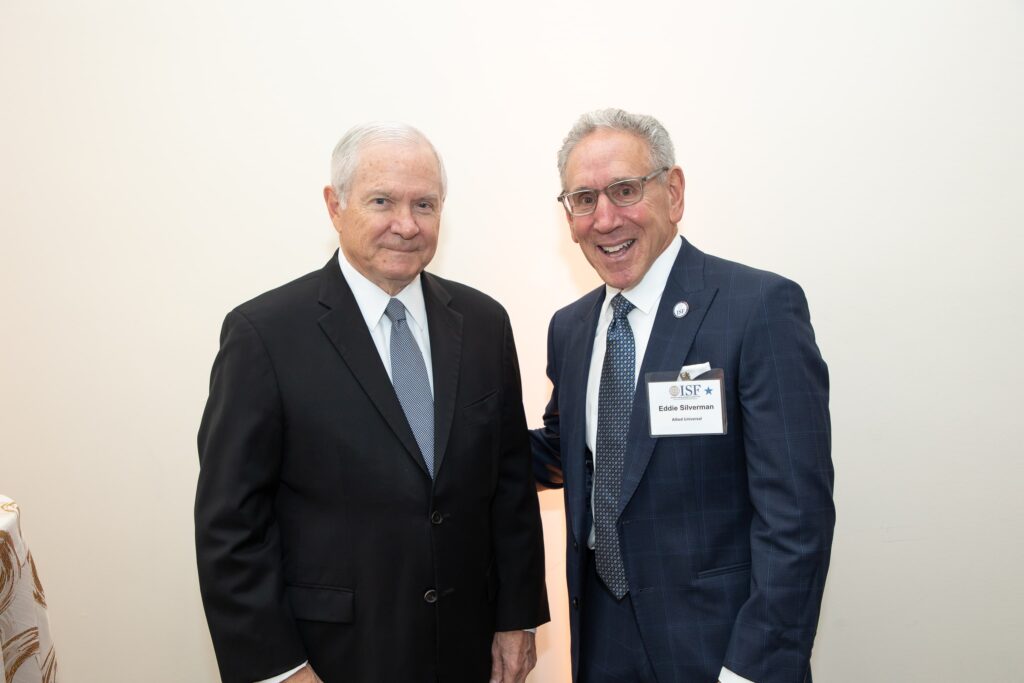 two men standing next to each other in suits