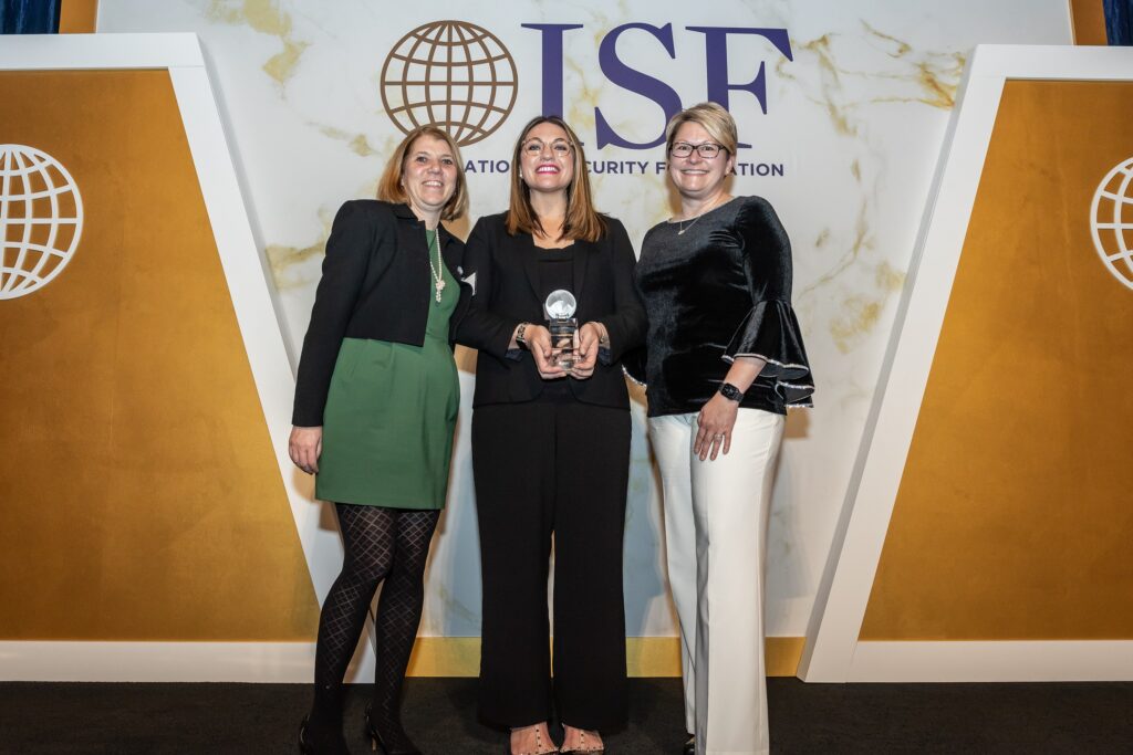 three women standing next to each other holding an award