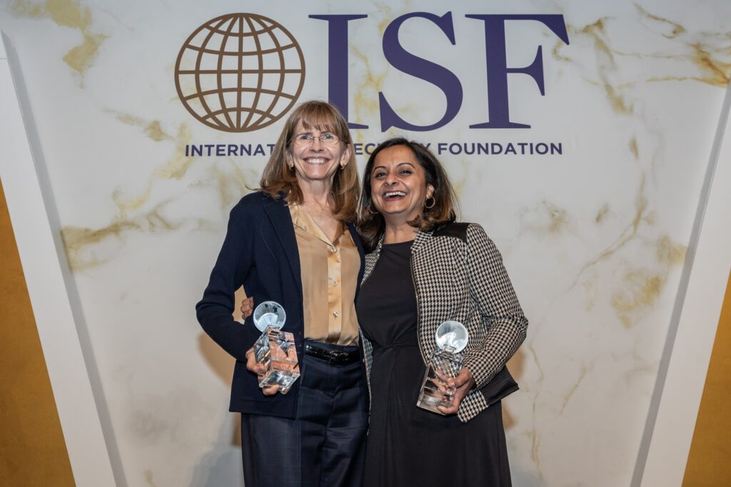 two women standing next to each other holding their awards