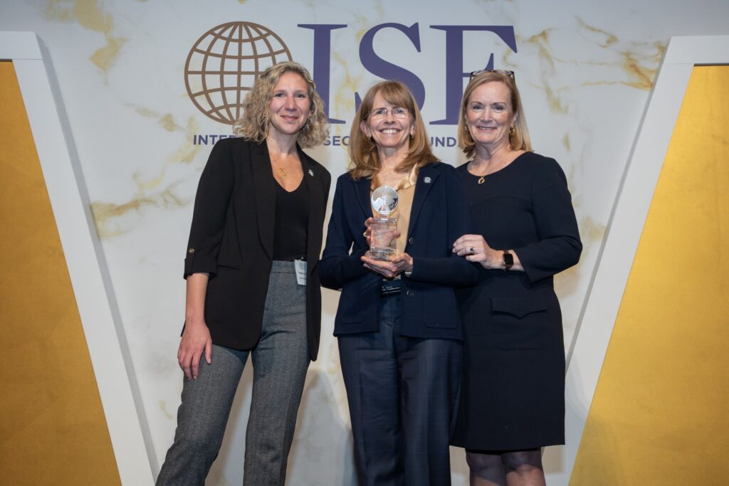 three women standing next to each other holding an award