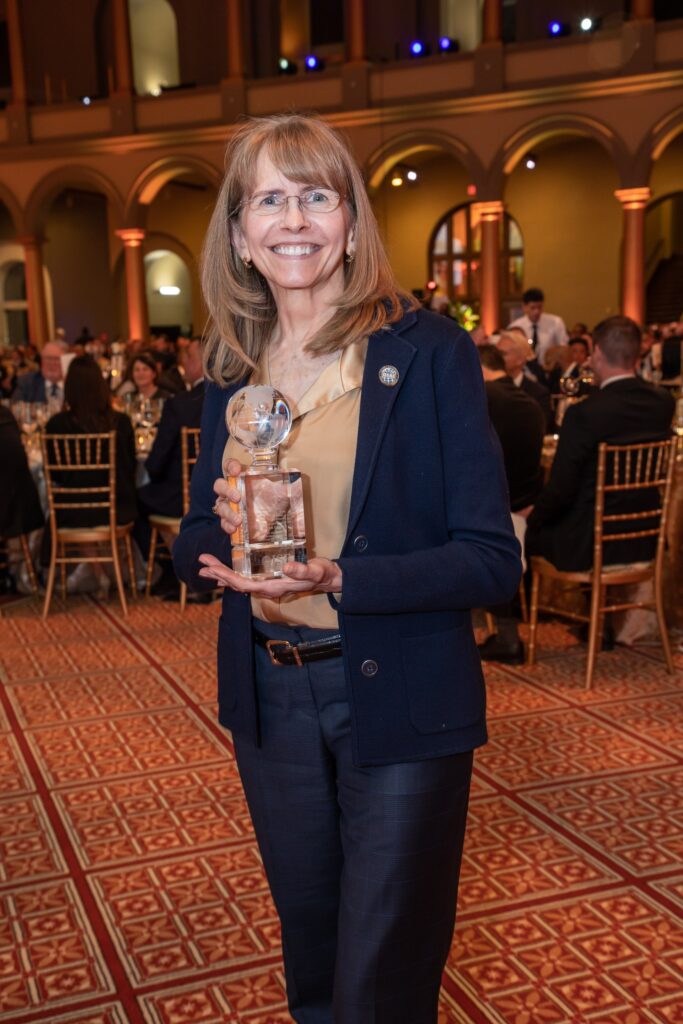 a woman standing in a room holding an award