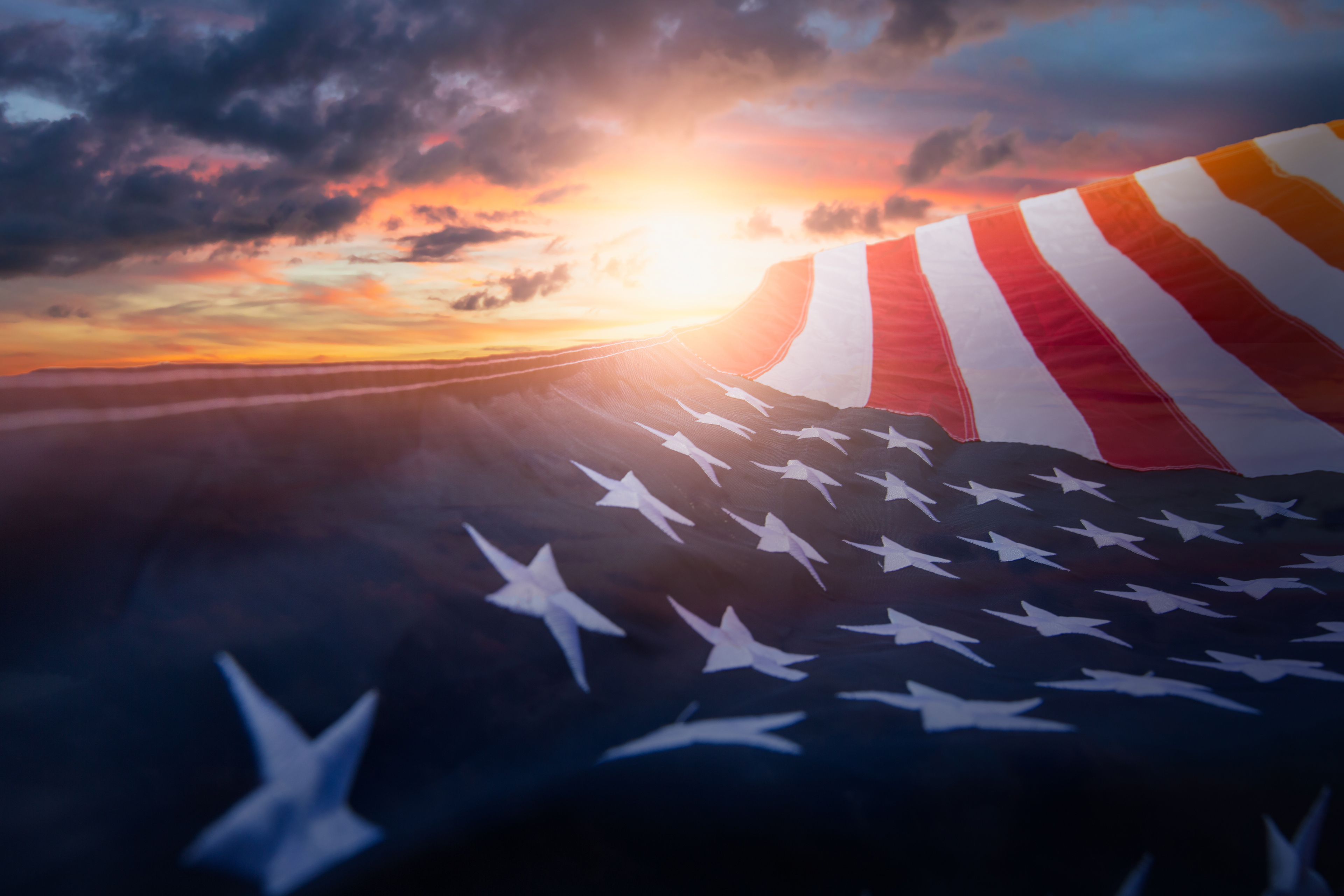 image of the american flag with the sunset in the background